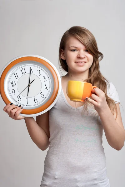 Portrait of a girl with a cup and a clock — Stock Photo, Image