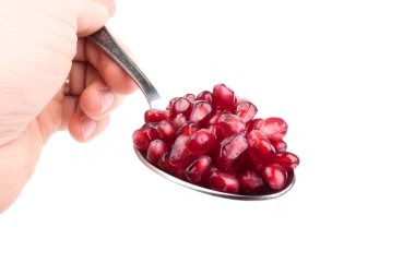 Pomegranate seeds on the spoon clipart