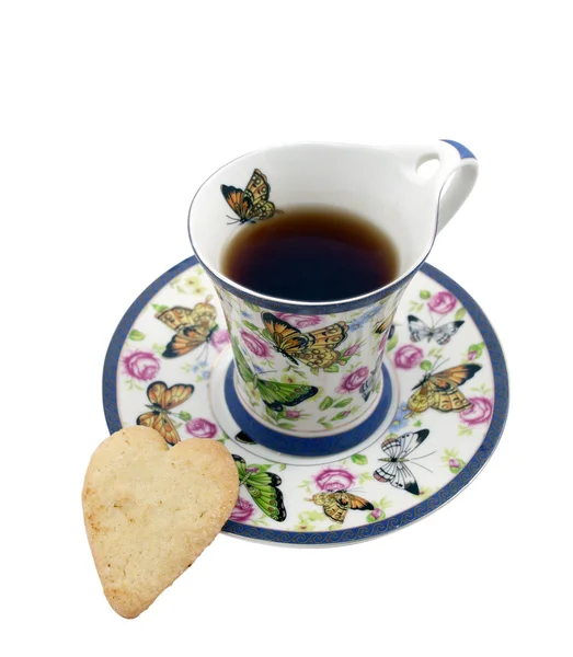 Taza de té con una galleta en forma de corazón — Foto de Stock