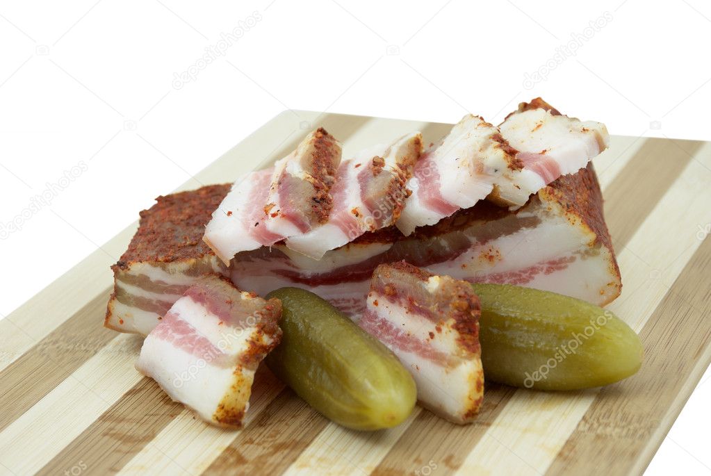 Salted cucumbers and smoked bacon on a hardboard