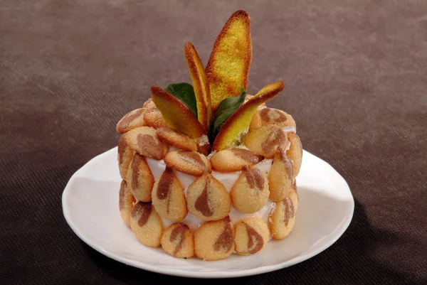 Kuchen, dekoriert mit künstlichen Blütenblättern auf einem Teller — Stockfoto