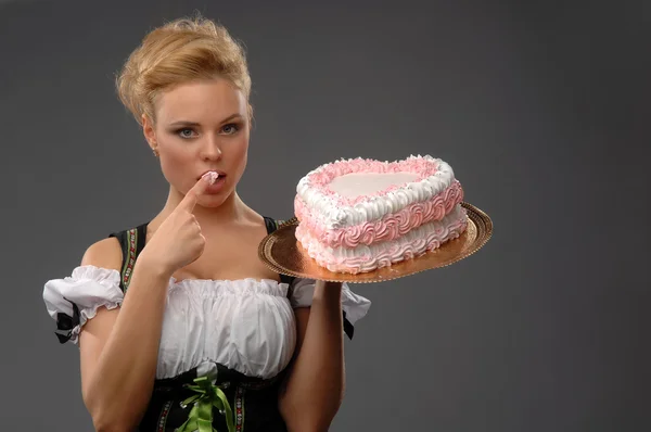 Hübsche Hausfrau mit einem großen Kuchen — Stockfoto