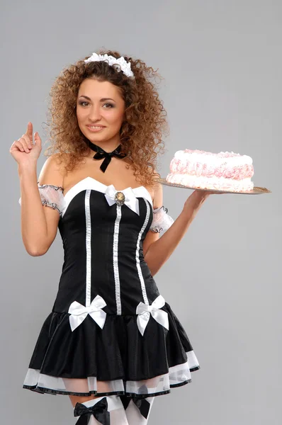 Empregada bonita com um bolo em uma bandeja — Fotografia de Stock