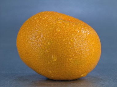 Ripe orange fruit is covered with water droplets