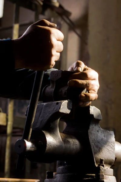 Trabalhador protege o item em aperto mecânico — Fotografia de Stock