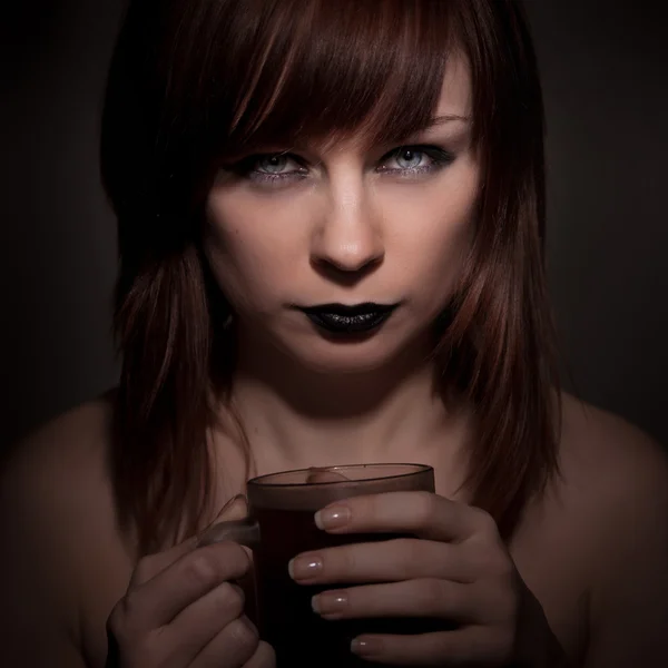 Gothic girl with black lipstick on her lips, holding a cup — Stock Photo, Image