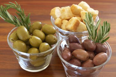 Two jars of green and black olives and croutons clipart