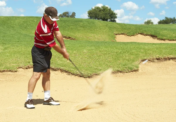 年長のゴルファーが砂のバンカーからゴルフ — ストック写真