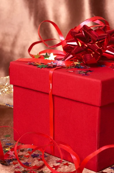Красная подарочная коробка с луками и звездами — стоковое фото