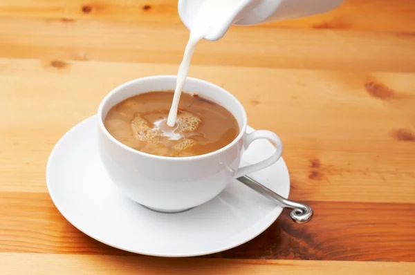 Nahaufnahme von Milch, die in den Kaffee gegossen wird — Stockfoto