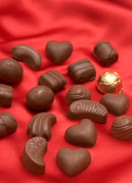 Valentines chocolates on red silk — Stock Photo, Image