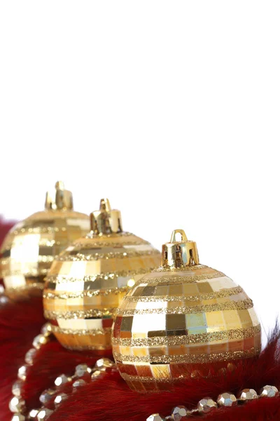 Golden Christmas baubles on fur — Stock Photo, Image