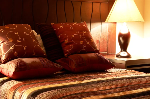 Almofadas coloridas na cama — Fotografia de Stock