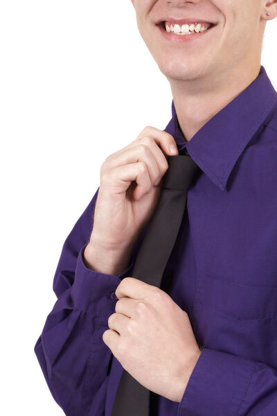 Young successful businessman wearing an office shirt and fixing his tie. Isolated on white background