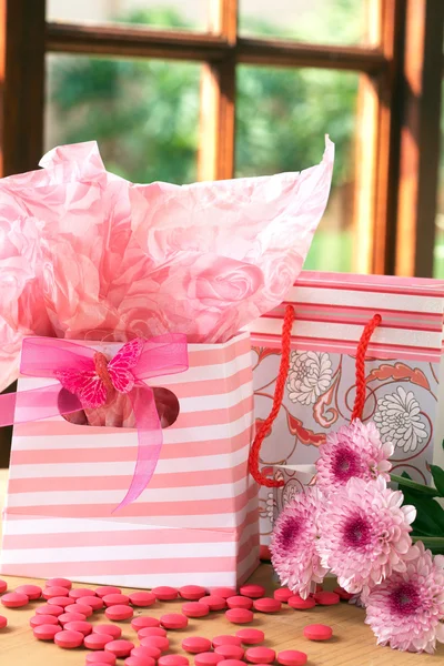Twee geschenk zakken met roze snoep rond — Stockfoto