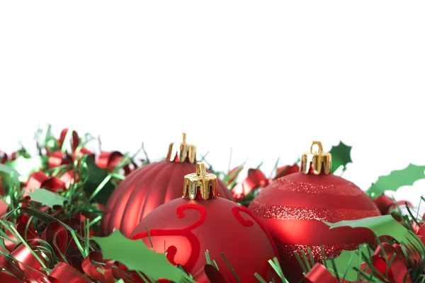 Üç kırmızı Noel baubles tinsel üzerinde — Stok fotoğraf
