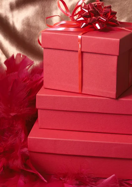 Red gift boxes with feathers and a bow — Stock Photo, Image