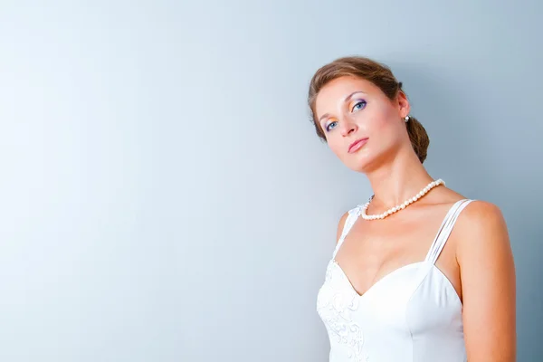 Studio portrait of the bride against a gray wall — Stock Photo, Image