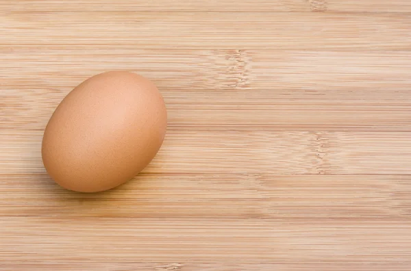 Egyetlen tojás a fából készült asztal nézet felülről, a szöveg tér — Stock Fotó