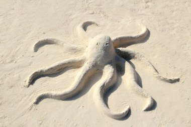 Sand octopus sculpture in white beach clipart