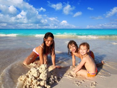 Three little girls mixed ethnicity playing beach clipart