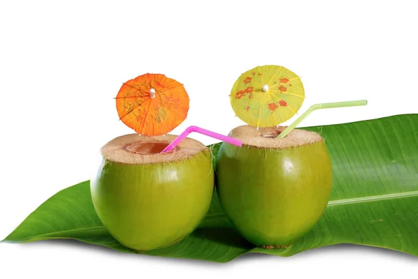 Coconut beverage straw cocktail on banana tree leaf — Stock Photo, Image