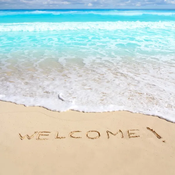 Saludos bienvenidos playa hechizo escrito en la arena — Foto de Stock