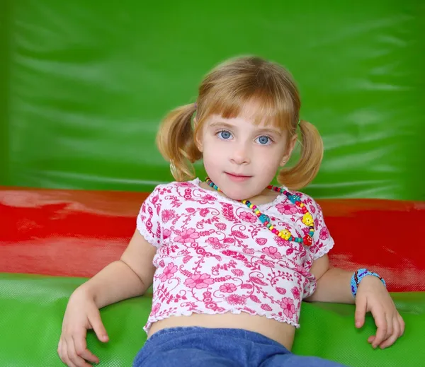 Bionda bambina che riposa su un parco giochi colorato — Foto Stock