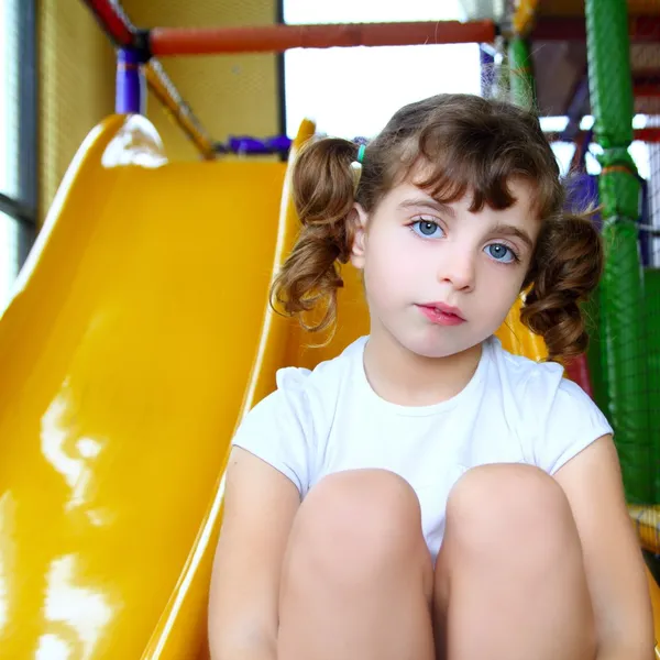 Menina no playground colorido slide amarelo — Fotografia de Stock