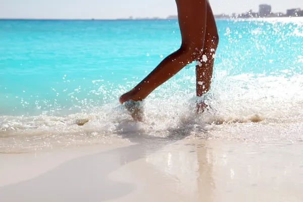 Жінка ноги ходьба бризкаючи пляж аква-вода — стокове фото