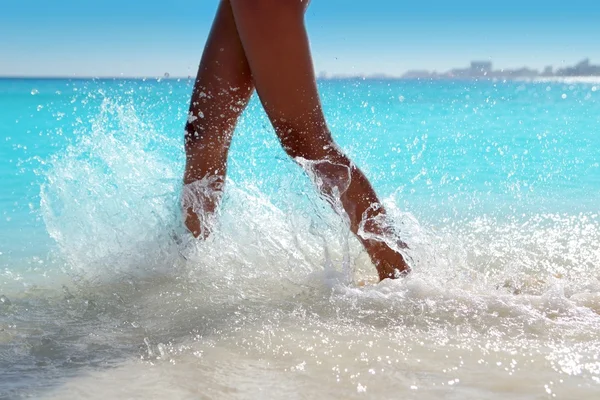 Nő lábak séta fröccsenő part víz — Stock Fotó
