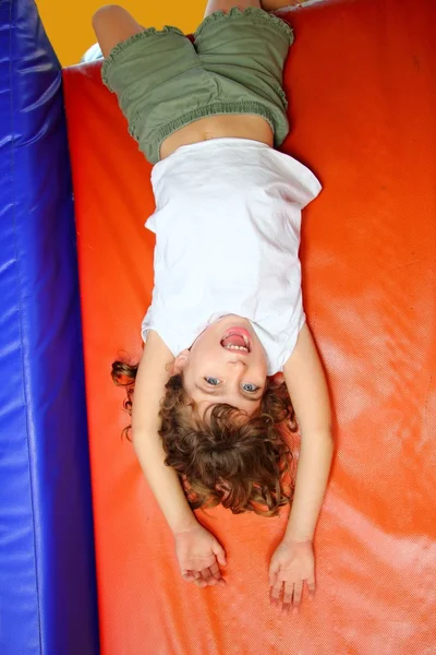 De cabeça para baixo menina no playground slide rindo — Fotografia de Stock