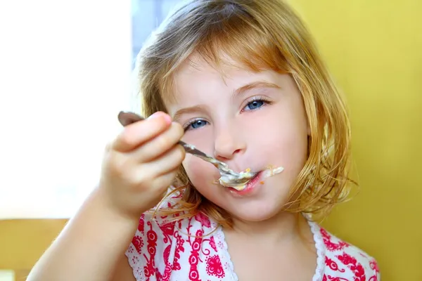 Πεινασμένος μικρό κουτάλι ξανθιά κοπέλα που τρώει παγωτό — Φωτογραφία Αρχείου