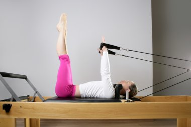 Gym woman pilates stretching sport in reformer bed clipart