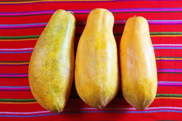 Three papaya fruits on latin serape tablecloth — Stock Photo, Image