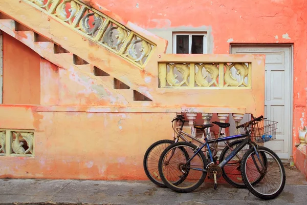 Cyklar på grunge tropiska Karibien orange fasad — Stockfoto