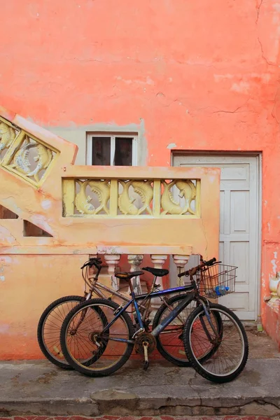 Kerékpárok a grunge trópusi karibi narancssárga homlokzat — Stock Fotó