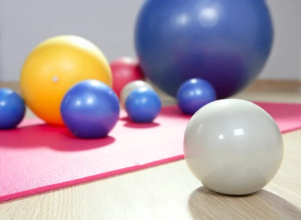 安定性のボールとピラティス スポーツ ジム ヨガマットの調子を整える — ストック写真