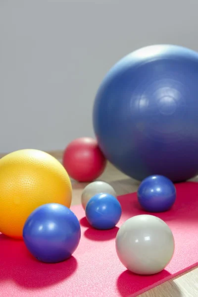 安定性のボールとピラティス スポーツ ジム ヨガマットの調子を整える — ストック写真