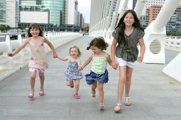 Fyra små tjejgruppen promenader i staden — Stockfoto