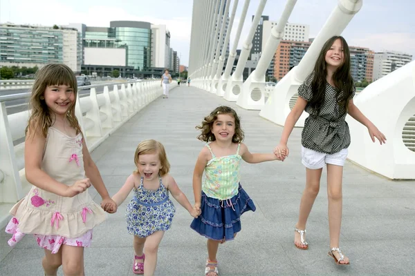 Fyra små tjejgruppen promenader i staden — Stockfoto