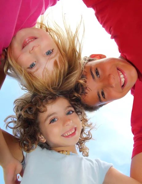 Abaixo vista de feliz três crianças abraçando — Fotografia de Stock