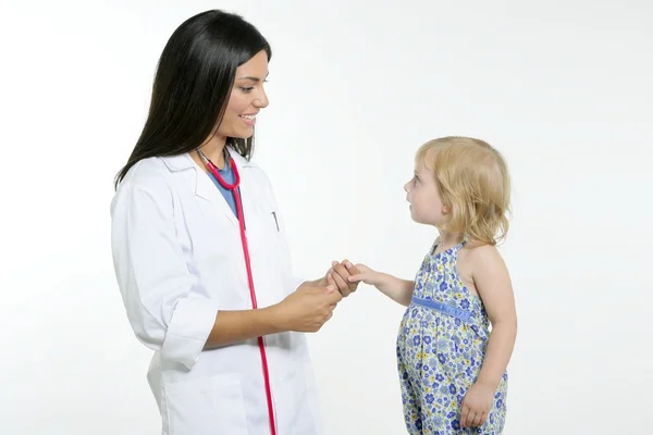 Brunette pediatric doctor with blond little girl Stock Photo