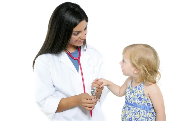 Brunette pediatric doctor with blond little girl Royalty Free Stock Photos
