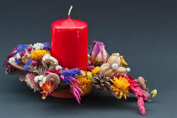 stock image Decoration of dry flowers with a red candle