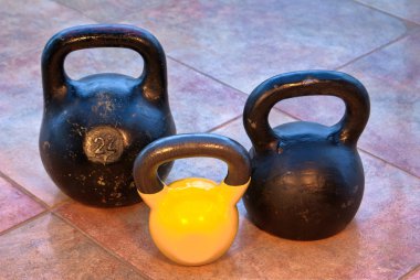 Three kettlebells on flagging clipart