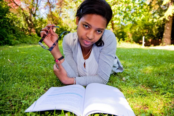 Genç bir öğrenci okul Park kitap okuma — Stok fotoğraf