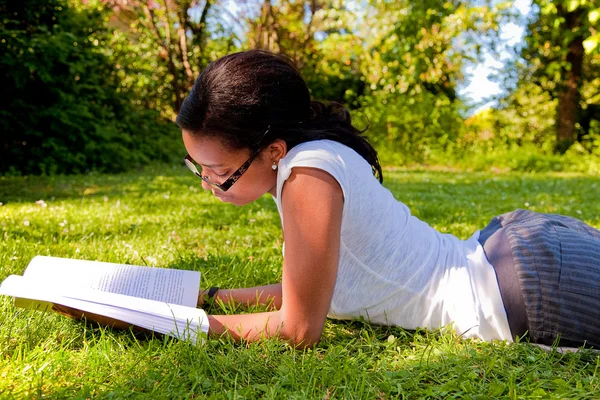 Jovem estudante lendo livros no parque escolar — Fotografia de Stock