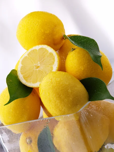 Frische nasse Zitrone mit grünem Blatt auf weißem Hintergrund — Stockfoto