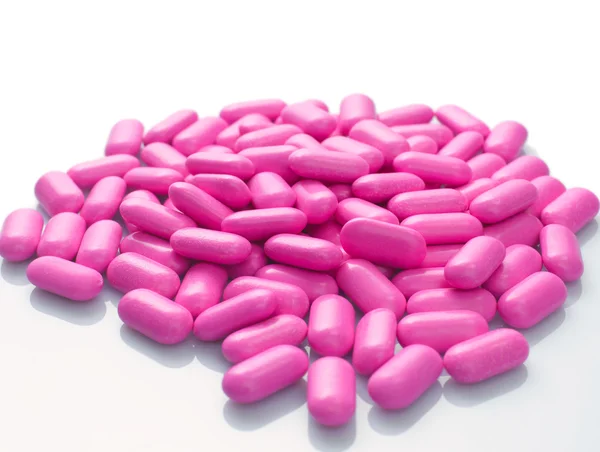 Cápsulas cor de rosa sobre fundo branco — Fotografia de Stock